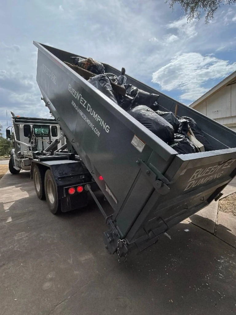 Ruff'N EZ hydraulic hook-lift truck delivering roll-off dumpster